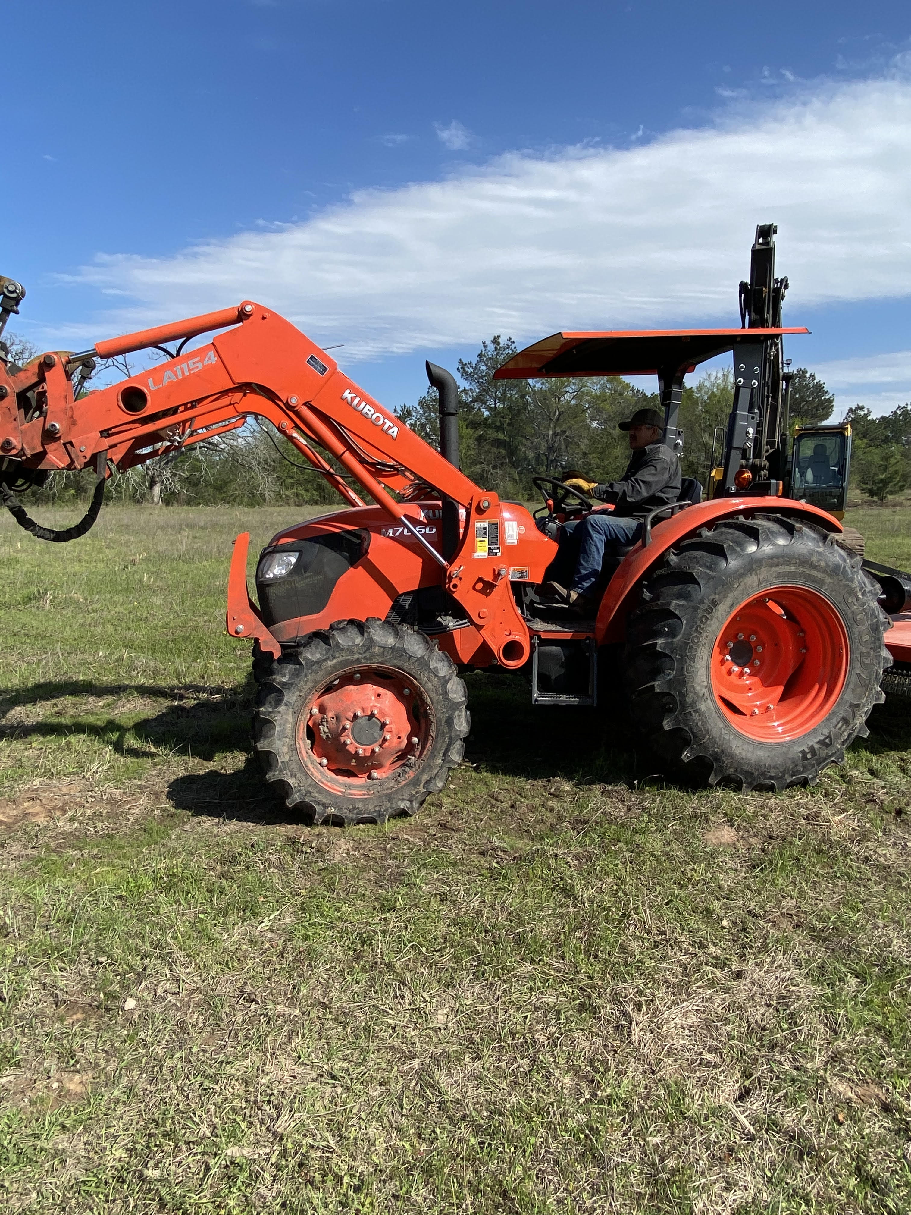 Commercial-grade tractor with loader used for land clearing and tree services in Huntsville, TX